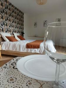 a bedroom with a bed and a table with a wine glass at Ma Bulle Confort in Pouzauges