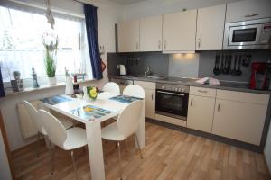 a kitchen with a table and chairs in a kitchen at Ferienhaus Victoria in Norden