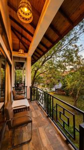 a balcony with a table and chairs and a chandelier at Gatetrees resort in Jaffna