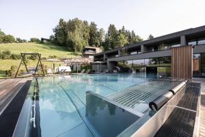 a large swimming pool in front of a building at Hotel Viertler in Avelengo
