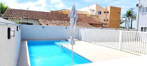 a blue swimming pool with an umbrella and an umbrella at Beira-Mar Sofisticado com Vista Mar e Piscina in Pontal do Paraná