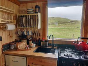 a kitchen with a sink and a stove and a window at Bothan na Mara in Valtos