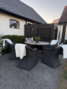 eine Terrasse mit Tisch und Stühlen und ein Tisch und Stühle in der Unterkunft Studio Sommar in Glemmingebro