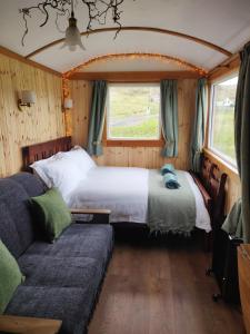 a bedroom with a bed and a couch in a room at Bothan na Mara in Valtos