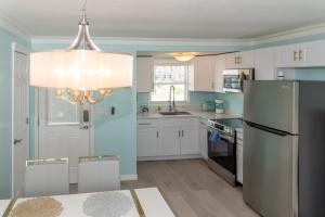 eine Küche mit weißen Schränken und einem schwarzen Kühlschrank in der Unterkunft Flamingo Inn in Fort Myers Beach