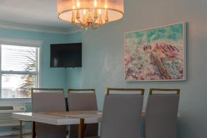 ein Esszimmer mit Tisch und Stühlen und einem Gemälde in der Unterkunft Flamingo Inn in Fort Myers Beach