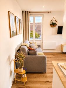 a living room with a couch and a window at Cocon avec terrasse proche plages et centre in Dives-sur-Mer