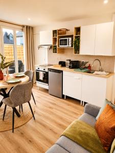 a kitchen and living room with a couch and a table at Cocon avec terrasse proche plages et centre in Dives-sur-Mer