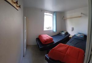 a small room with two beds and a window at Mobile-Home L'Instant Marin in Sérignan +15 photos