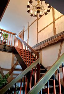 a wooden staircase in a house with a chandelier at Krusenhofilona in Krusendorf +3 photos