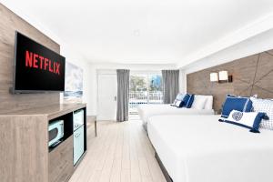 a hotel room with a bed and a flat screen tv at Fin's Inn & Suites in Myrtle Beach