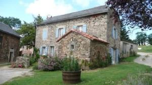 a large stone house with a garden in front of it at Gîte La Mirgue in Sanvensa