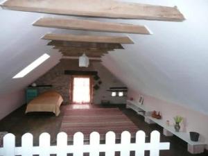 a attic room with a white fence and a window at Gîte La Mirgue in Sanvensa +4 photos