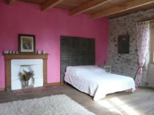 a bedroom with a white bed and a pink wall at Gîte La Mirgue in Sanvensa