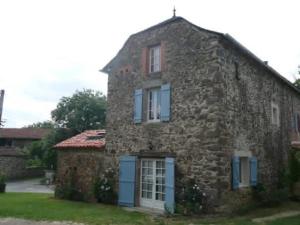 an old stone house with blue doors and windows at Gîte La Mirgue in Sanvensa