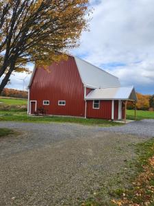 a red barn with a tree next to it at The Stable at Windmill Ridge Farm in Fredonia