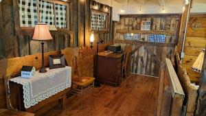 a room with a table and a lamp and wooden walls at The Stable at Windmill Ridge Farm in Fredonia