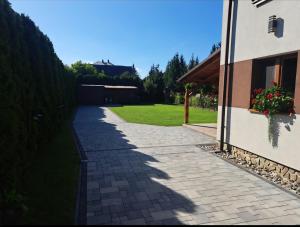 a brick sidewalk next to a house with a window at Pod Dachem Tykocin in Tykocin