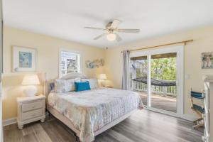 a bedroom with a bed and a sliding glass door at Beach Nutz in Nags Head +131 photos