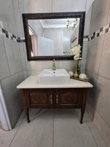 a bathroom with a sink and a mirror at 21on2nd Avenue in Tzaneen +28 photos