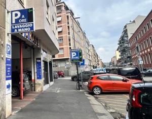 a parking lot with a red car parked on a street at MILANO Central Station House in Milan