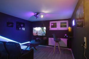 a living room with purple lights on the ceiling at Blackhillhouse - Moderne Auszeit im Harz in Osterode