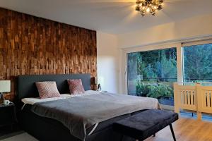 a bedroom with a bed and a large window at Blackhillhouse - Moderne Auszeit im Harz in Osterode