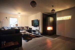 a living room with a couch and a table at Blackhillhouse - Moderne Auszeit im Harz in Osterode