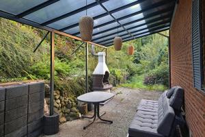 a patio with a table and a chair and a vase at Blackhillhouse - Moderne Auszeit im Harz in Osterode +9 photos