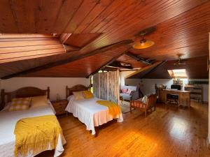 a bedroom with two beds in a room with wooden ceilings at Casa Mayucu in Celis