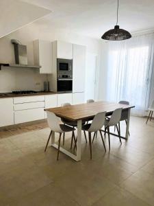 a kitchen with a wooden table and chairs at Il PuntoPiu'Alto in SantʼAntìoco