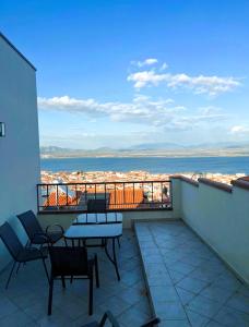a balcony with chairs and tables and a view of the ocean at Il PuntoPiu'Alto in SantʼAntìoco