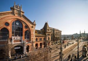a large building with a clock tower on a street at SOPHIA PALACE Hotel Budapest in Budapest