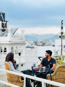 a man and a woman sitting in chairs on a boat at Old Skool Udaipur - 20 Meter From Lake in Udaipur