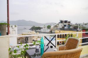 a balcony with chairs and a view of the water at Old Skool Udaipur - 20 Meter From Lake in Udaipur