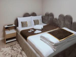 a bedroom with a large bed with a large headboard at Delfinului Retreat in Ovidiu