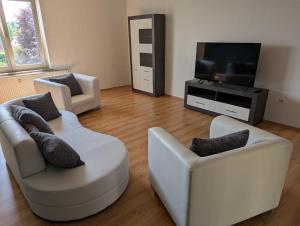 a living room with two chairs and a flat screen tv at Ferienwohnung Altstadt Lemgo in Lemgo