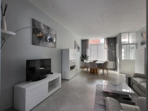 a white living room with a television and a table at Loéli's House in Tourcoing