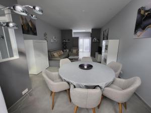 a dining room and living room with a table and chairs at Loéli's House in Tourcoing