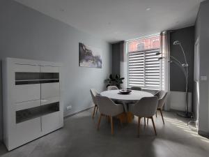 a dining room with a white table and chairs at Loéli's House in Tourcoing