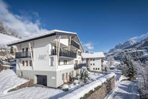 a white apartment building in the snow at Living Puez in Funes