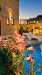 a pool with pink flowers in front of a building at WesamFarm in Amman