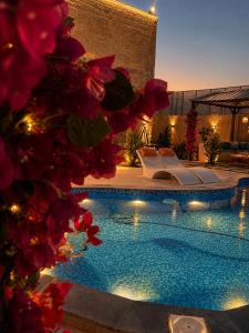 a swimming pool with chairs and flowers in front of a building at WesamFarm in Amman