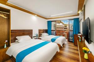a hotel room with three beds and a balcony at LQJ Riverside Guest House in Fenghuang County