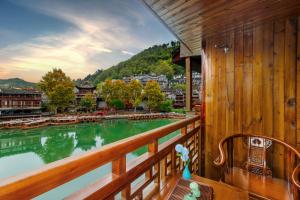 a balcony with a view of a river at LQJ Riverside Guest House in Fenghuang County