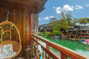 a balcony with a view of a river at LQJ Riverside Guest House in Fenghuang County