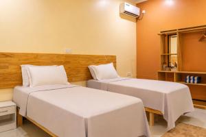 two beds in a hotel room with white sheets at Sansara Maldives - The Untouched South, Easy Access via Sri Lanka in Meedhoo