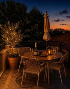 a table with a bottle of wine and a umbrella at Romantic loft in Tríkala +16 photos