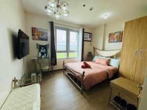 a bedroom with a bed with pink sheets and a window at The Cozy Rustic in General Trias