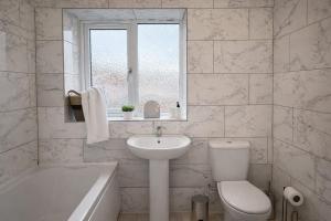 a white bathroom with a sink and a toilet and a tub at Fully Equipped Homely Heaven in Houghton le Spring +23 photos